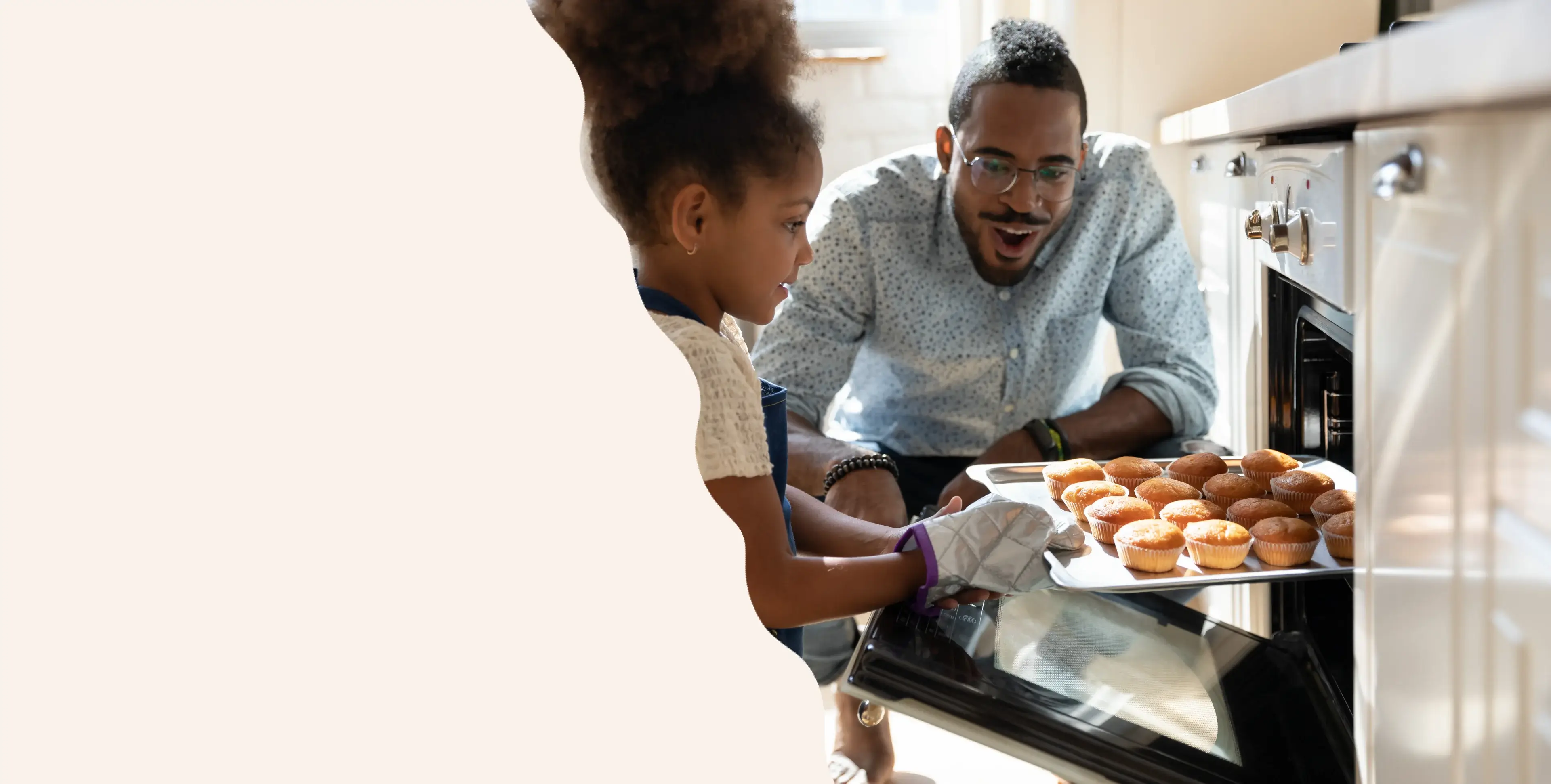 A man and child are making doughnuts together.